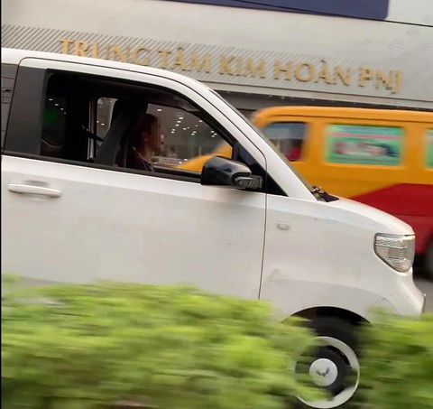 Hình ảnh người phụ nữ lái xe ô tô điện mini đi ngược chiều trên quốc lộ 13 - Ảnh cắt từ video Tước giấy phép người phụ nữ lái xe đi ngược chiều trên quốc lộ- Ảnh 1.