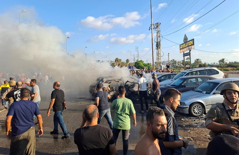Người dân Lebanon tại hiện trường một xe ô tô bị không kích ở TP Sidon hôm 9-8 - Ảnh: REUTERS Việt Nam sẽ hoàn thiện các phương án bảo hộ công dân tại Israel, Iran, Lebanon- Ảnh 1.