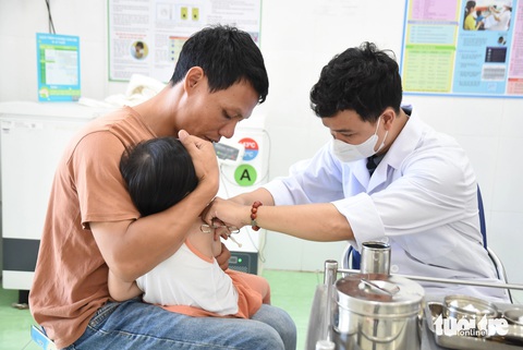 Lo dịch sởi, phụ huynh TP.HCM gấp rút đưa con đi tiêm vắc xin- Ảnh 1. Phụ huynh đưa con đi tiêm vắc xin phòng bệnh tại Trạm y tế phường Phước Long A (TP Thủ Đức) - Ảnh: THU HIẾN