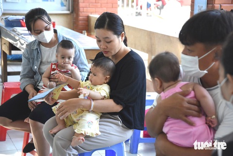 Lo dịch sởi, phụ huynh TP.HCM gấp rút đưa con đi tiêm vắc xin- Ảnh 3. Nhiều phụ huynh xếp hàng từ rất sớm đợi đến lượt tiêm vắc xin cho con, trong đó có vắc xin phòng sởi - Ảnh: THU HIẾN