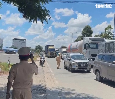 Cảnh sát giao thông tỉnh Bình Dương ghi hình và lập biên bản xử phạt các trường hợp ô tô lấn làn xe máy ngày 13-8 - Ảnh: B.S. Cảnh sát giao thông Bình Dương ghi hình xử phạt ô tô lấn làn xe máy- Ảnh 1.