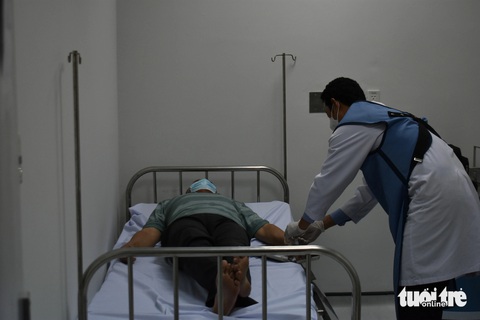 Kiên Giang sử dụng máy chẩn đoán ung thư đầu tiên tại Đồng bằng sông Cửu Long- Ảnh 1. Bác sĩ đến từ Bệnh viện Chợ Rẫy tiêm thuốc phóng xạ vào bệnh nhân điều trị ung thư - Ảnh: BỬU ĐẤU