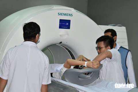 Kiên Giang sử dụng máy chẩn đoán ung thư đầu tiên tại Đồng bằng sông Cửu Long- Ảnh 2. Các bác sĩ đưa bệnh nhân đầu tiên vào máy chụp PET-CT để chẩn đoán, đánh giá chính xác giai đoạn ung thư của bệnh nhân - Ảnh: BỬU ĐẤU