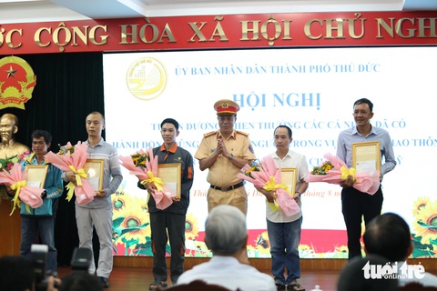 Trao bằng khen của UBND TP.HCM cho những 'người hùng' cứu người ở cầu Phú Mỹ- Ảnh 2. Dịp này, năm cá nhân cũng nhận thư khen của giám đốc Công an TP.HCM. Thượng tá Trần Trung Hiếu, trưởng Phòng cảnh sát giao thông, thay mặt trao thư khen cho năm cá nhân - Ảnh: MINH HÒA