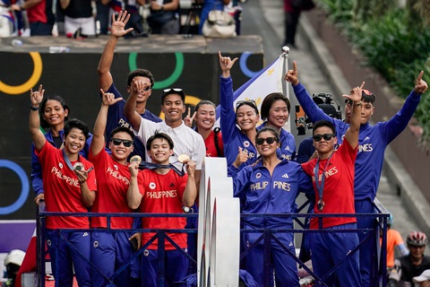 Hàng ngàn người Philippines đổ ra đường đón người hùng Olympic Carlos Yulo- Ảnh 3. Các VĐV Philippines diễu hành quanh đường phố tại thủ đô Manila trên một chiếc xe buýt mui trần - Ảnh: REUTERS