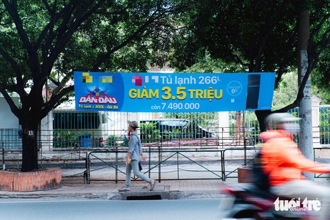 Bảng quảng cáo cỡ lớn với màu sắc sặc sỡ được treo bắt ngang giữa hàng cây xanh tại trên đường Xuân Hồng, quận Tân Bình - Ảnh: THANH HIỆP Băng rôn quảng cáo treo ngang giữa hàng cây xanh trên đường Xuân Hồng, quận Tân Bình - Ảnh: THANH HIỆP