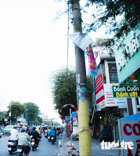 Một áp phích quảng cáo treo ngổn ngang trên đường Trường Chinh, quận Tân Bình - Ảnh: THANH HIỆP Băng rôn quảng cáo bủa vây gốc cây, cột điện, che lấp biển báo giao thông- Ảnh 6.