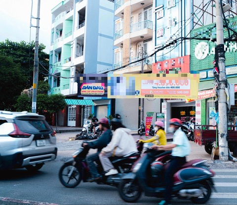 Một tấm bạt quảng cáo khổ lớn được treo nhếch nhác tại ngã tư đường Âu Cơ giao với đường Lạc Long Quân, quận Tân Bình - Ảnh: THANH HIỆP Băng rôn quảng cáo bủa vây gốc cây, cột điện, che lấp biển báo giao thông- Ảnh 3.