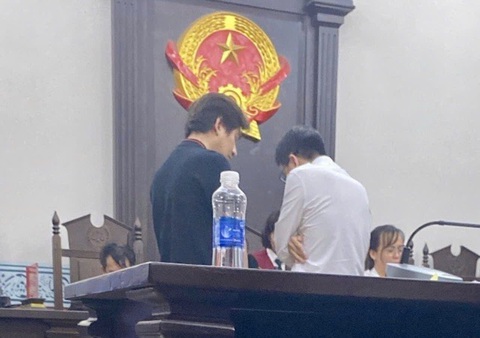 Vụ kiện liên quan công ty Sơn Tùng M-TP: Tòa có micro nhưng không mở, chủ tọa đọc nhỏ do... đau họng- Ảnh 2. Hai đương sự lên bàn thư ký để nghe tuyên án, nhưng cũng không nghe thấy gì - Ảnh: H.D