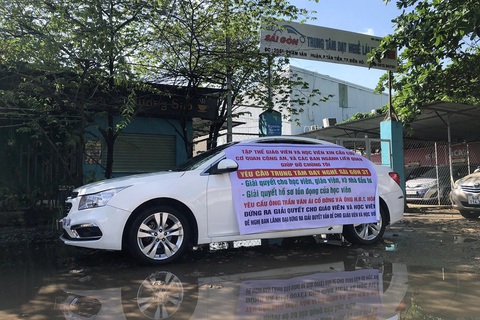 Công bố số điện thoại để 63.000 học viên Trung tâm dạy nghề lái xe Sài Gòn liên hệ công an- Ảnh 1. Giáo viên, học viên giăng băng rôn