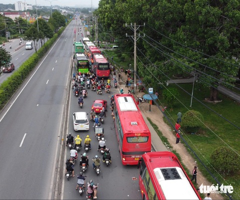 Xe dàn hàng ngang trên quốc lộ 1 đón khách, lực lượng chức năng nói 'xử lý không xuể'- Ảnh 2. Xe khách đậu chắn hết đường gây cản trở giao thông, nhiều người đi xe máy qua đoạn này phản ánh thường xuyên gặp tình trạng này - Ảnh: MINH HÒA