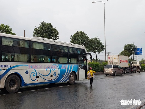 Xe dàn hàng ngang trên quốc lộ 1 đón khách, lực lượng chức năng nói 'xử lý không xuể'- Ảnh 7. Nhiều nhà xe bất chấp nguy hiểm, đón khách chớp nhoáng ngay giữa quốc lộ 1, ngày 2-8 - Ảnh: ĐÌNH KHẢI