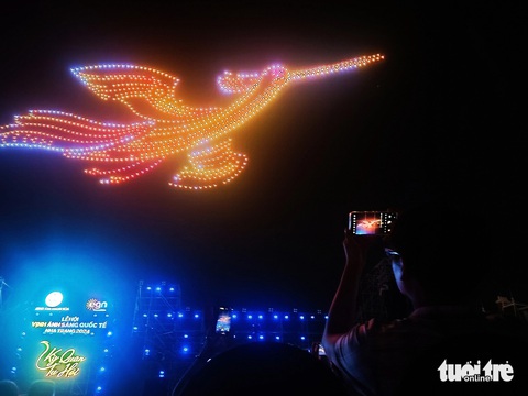 Drone 'vẽ' trống đồng, chim Lạc... trên vịnh Nha Trang- Ảnh 1. Một du khách chụp lại hình ảnh chim Lạc - Ảnh: TRẦN HOÀI