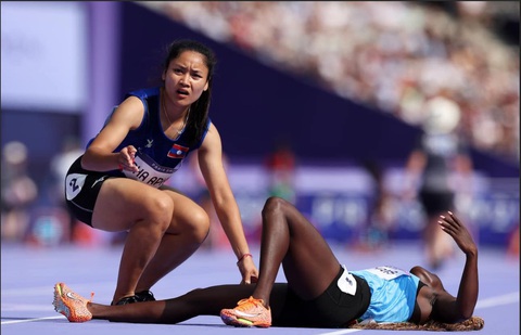 Nữ VĐV Lào giúp đối thủ bị té trên đường chạy Olympic 2024- Ảnh 1. Silinia Pha Aphay (Lào) giúp đối thủ té ngã trên đường chạy tại Olympic 2024 - Ảnh: Getty