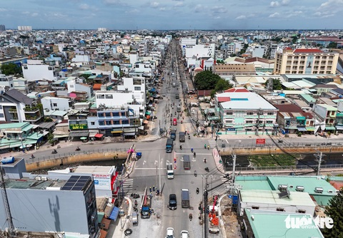 Loạt dự án cầu đường quan trọng ở TP.HCM về đích trong năm 2024- Ảnh 8. Các đơn vị di dời cột đèn tín hiệu giao thông tại giao lộ Tân Kỳ Tân Quý - kênh Nước Đen (quận Bình Tân, TP.HCM) để có mặt bằng hoàn thành dự án mở rộng đường. Ghi nhận vào ngày 29-7 - Ảnh: CHÂU TUẤN