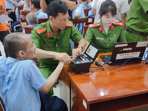 Người khuyết tật ở TP.HCM được cấp căn cước: 'Tôi vui lắm, sẽ giữ nó thật kỹ'- Ảnh 5. Một trường hợp khó lấy dấu vân tay nhưng các cán bộ, chiến sĩ đã nỗ lực lấy được và thực hiện các bước làm căn cước - Ảnh: MINH HÒA