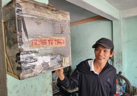 Anh Huỳnh Văn Phước bên thùng từ thiện để trong tiệm sửa xe của mình - Ảnh: TRẦN MAI Phước 'khùng' dễ thương và tiệm sửa xe dìu nhau qua những đoạn ngặt nghèo- Ảnh 5.