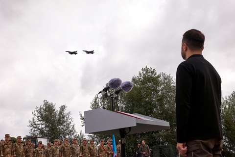 Tiêm kích F-16 đã bay trên bầu trời, nhưng 'có một thứ quan trọng Ukraine cần làm'- Ảnh 1. Tổng thống Ukraine Volodymyr Zelensky nhìn các tiêm kích F-16 trên bầu trời, trong sự kiện đánh dấu Ngày Không quân Ukraine tại một địa điểm không được tiết lộ ở Ukraine hôm 4-8 - Ảnh: REUTERS