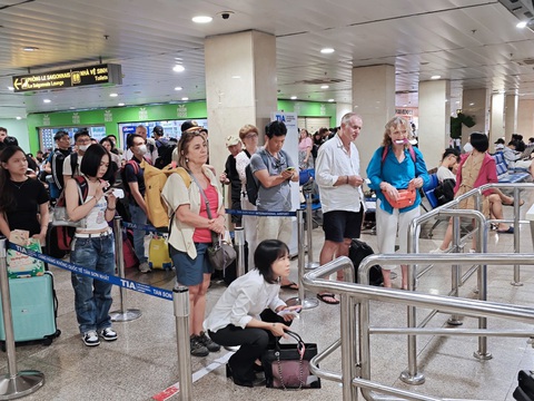 Đi chơi hè, giá vé máy bay giảm nhưng mất vui vì delay- Ảnh 1. Hành khách đứng sát cửa ra máy bay sau thời gian chờ đợi vì delay. Có người mệt mỏi phải ngồi để chờ giờ lên máy bay - Ảnh: CÔNG TRUNG