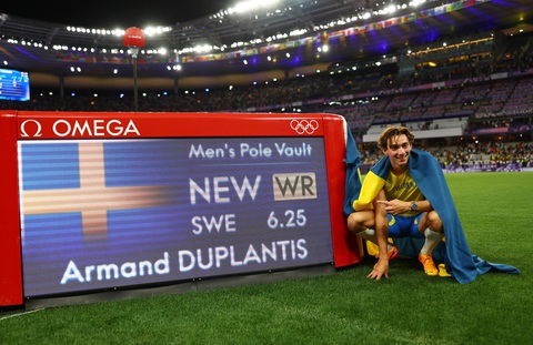 Mondo Duplantis qua mức sào 6,25m, phá kỷ lục thế giới tại Olympic 2024- Ảnh 3. Mondo Duplantis chụp ảnh bên cạnh kỷ lục của mình - Ảnh: REUTERS