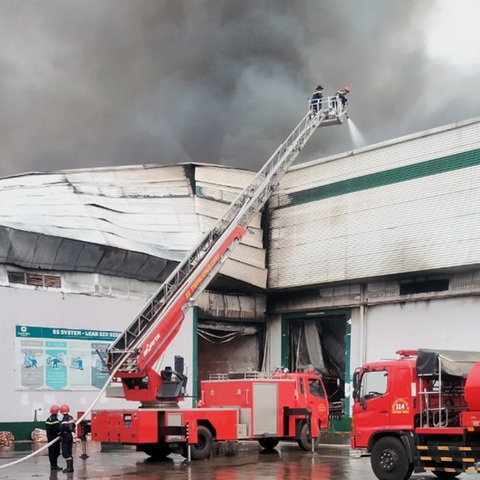 Công ty chế biến hạt điều ở Bình Phước cháy lớn lúc rạng sáng- Ảnh 2. Lực lượng chức năng sử dụng xe thang khống chế ngọn lửa từ trên cao - Ảnh: AN BÌNH