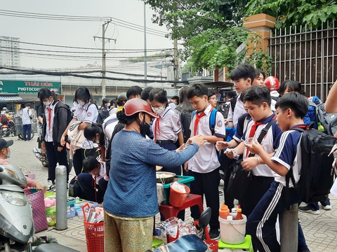 Gò Vấp đề xuất được thí điểm ủy quyền phê duyệt dự án căng tin, bãi xe trường học- Ảnh 1. Khi trường học có căng tin sẽ hạn chế được mua bán hàng rong ngoài cổng trường. Trong ảnh: học sinh tại một quận ở TP.HCM ùa ra mua hàng rong sau khi tan học - Ảnh: MỸ DUNG