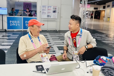 Olympic Paris 2024 tuần cuối: Tấp nập kẻ đến người đi- Ảnh 5. Nhà báo/nhiếp ảnh gia gốc Ý Giuliano Bevilacqua (83 tuổi, bên trái), người tác nghiệp 29 kỳ Olympic mùa hè và mùa đông trong sự nghiệp, trò chuyện với PV Trung Nghĩa tại Trung tâm báo chí Olympic Paris 2024 - Ảnh: TRUNG NGHĨA
