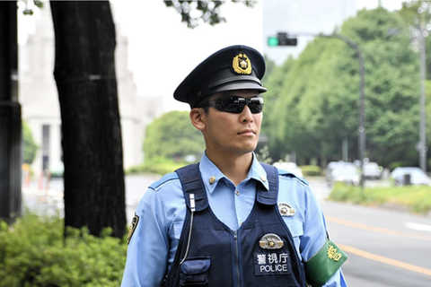 A mobile police unit officer wears sunglasses in Tokyo’s Chiyoda Ward on Aug. 5. Một cảnh sát cơ động đeo kính râm ở phường Ciyoda, Tokyo, ngày 5-8