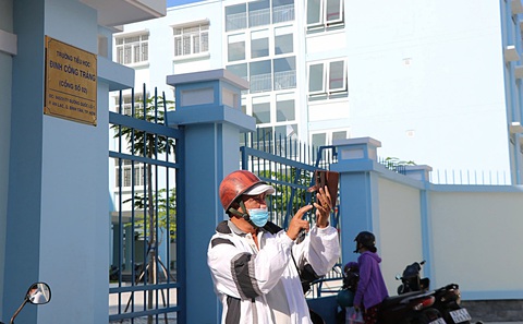 Phụ huynh háo hức chụp ảnh trước cổng Trường tiểu học Đinh Công Tráng mới được khánh thành ở quận Bình Tân, TP.HCM chiều 5-8 - Ảnh: CẨM NƯƠNG TP.HCM xây loạt trường mới đón năm học mới- Ảnh 3.
