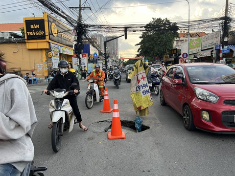 'Hố tử thần' xuất hiện giữa đường sau một ngày đêm vẫn chưa có đơn vị nào xử lý- Ảnh 3. Lực lượng của phường mang tới 3 cọc phản quang đặt quanh miệng hố - Ảnh: XUÂN ĐOÀN
