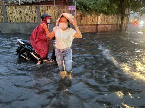 Thời tiết TP.HCM 'õng ẹo', chỗ mưa to chỗ lớt phớt- Ảnh 6. Nước dâng cao tại tuyến đường Quốc Hương (TP Thủ Đức), người dân xắn quần lội nước đi lại - Ảnh: TIẾN QUỐC