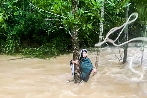 Ném dây thừng cứu người phụ nữ bị lũ cuốn trôi - Ảnh 1. Ném dây thừng cứu người phụ nữ bị lũ cuốn trôi - Ảnh 2.
