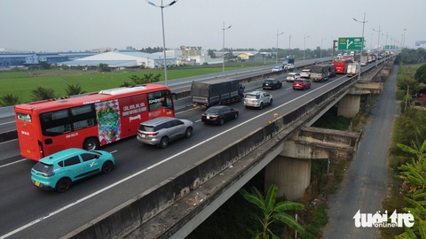 Xe đò tranh thủ quay đầu rước khách từ thành phố về quê khiến cao tốc ùn ứ - Ảnh 1.
