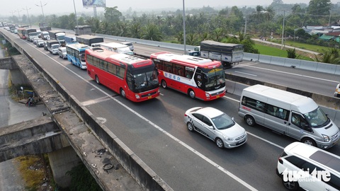 Xe đò tranh thủ quay đầu rước khách từ thành phố về quê, cao tốc ùn ứ - Ảnh 2.