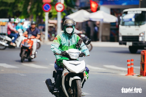 TP.HCM nắng nóng ‘đổ lửa’, người dân tìm đến tán cây, tài xế công nghệ dùng thuốc chống say nắng - Ảnh 8.