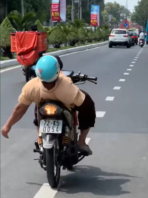 Công an vào cuộc người đàn ông khuyết tật nằm ngửa trên xe máy chạy trên đường - Ảnh 1. Công an vào cuộc vụ người đàn ông khuyết tật nằm ngửa trên xe máy chạy trên đường - Ảnh 1.