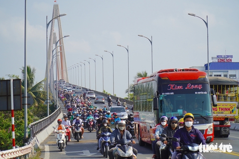 Người dân ùn ùn về quê, cầu Rạch Miễu lại kẹt xe - Ảnh 1.