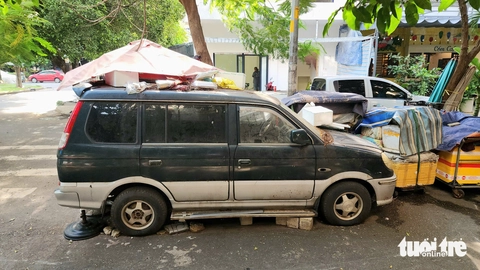 Xe hơi 7 chỗ đậu suốt 3 năm ở Tân Phú thành nơi bỏ rác, để đồ đạc - Ảnh 1.
