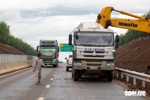 Xe đầu kéo, ô tô chạy nườm nượp trên cao tốc chưa khai thác, công nhân vừa làm vừa run - Ảnh 1.