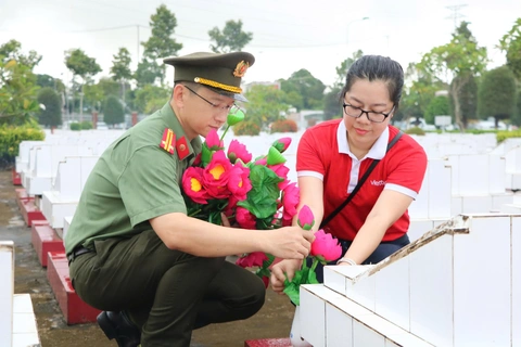 Tuổi trẻ Công an An Giang dọn dẹp, thay hoa cho hơn 9.000 mộ liệt sĩ - Ảnh 1.