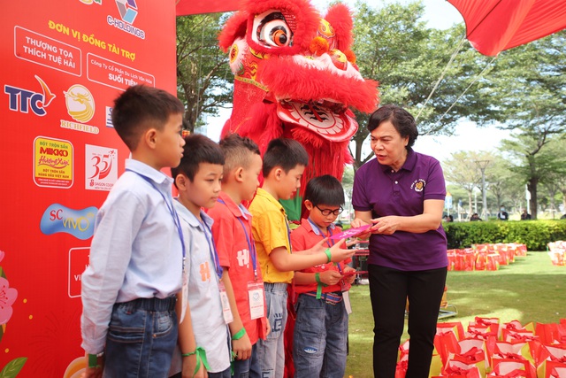 Bà Mai Thị Hạnh (Phu nhân Nguyên Chủ tịch nước Trương Tấn Sang) trao quà cho thiếu nhi trong chương trình Tết cho em diễn ra ngày 28-1 tại SC VivoCity - Ảnh: TRỌNG ANH