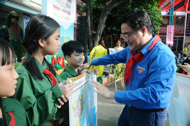 Anh Ngô Minh Hải (phó bí thư thường trực Thành Đoàn TP.HCM) trao bản đồ Việt Nam cho các chi đội. Ảnh: NGUYỄN HƯNG