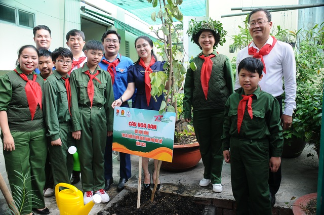 Các đại biểu và chiến sĩ nhỏ cùng trồng cây hoa ban. Ảnh: NGUYỄN HƯNG