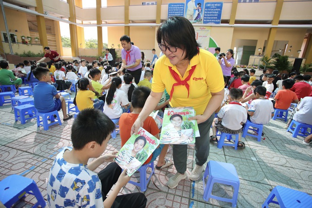 Các tờ báo được trao tận tay các em nhỏ - Ảnh: TRỌNG ANH