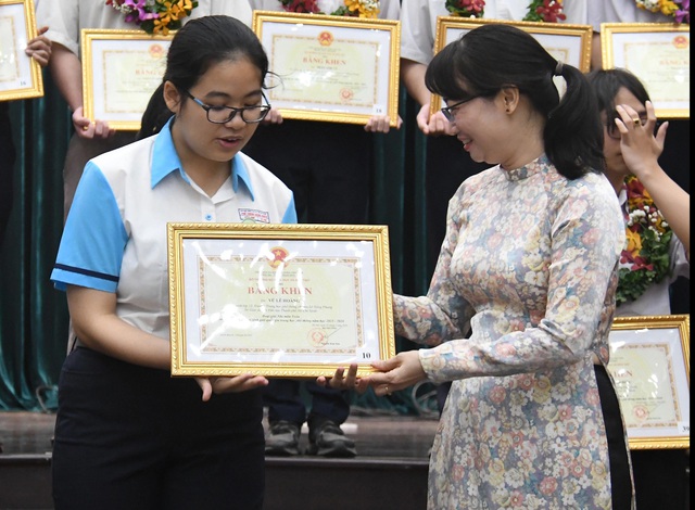 Cô Trần Thị Diệu Thúy (phó Chủ tịch Ủy ban Nhân dân TP.HCM) trao Bằng khen cho các bạn học sinh giỏi - Ảnh: NGUYỄN HƯNG