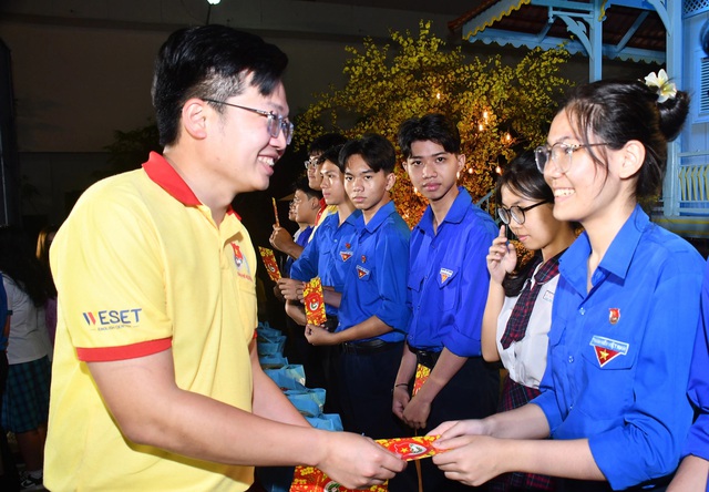 Anh Nguyễn Đức Trung - phó ban Thanh niên trường học Thành Đoàn  TP.HCM trao bao lì xi cho các bạn đoàn viên - Ảnh: N.H