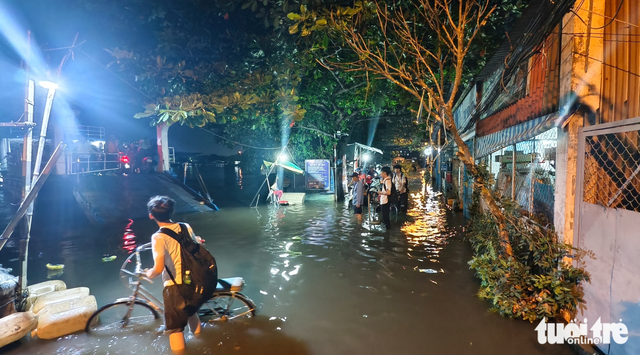 High tides turn Ho Chi Minh City streets into rivers  - Ảnh 8.