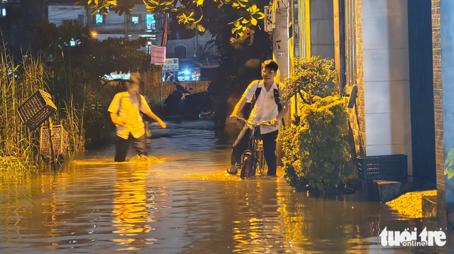 High tides turn Ho Chi Minh City streets into rivers  - Ảnh 7.