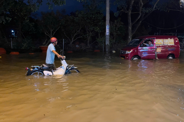 High tides turn Ho Chi Minh City streets into rivers  - Ảnh 9.