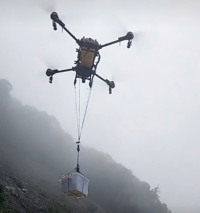 Drones deliver food to stranded drivers on central Vietnam pass amid landslides - Ảnh 1.